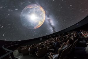 A view from inside the planetarium at the ESO Supernova Planetarium & Visitor Centre, which opened its doors to the public on Saturday 28 April 2018. The building is open five days a week and features planetarium screenings, tours and a permanent exhibition in both German and English. The 25-degree tilted planetarium dome does not just give the audience the sensation of watching the Universe, but of being immersed in it.