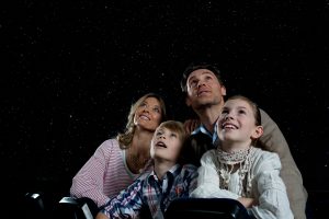 Familia mirando las estrellas en planetarios